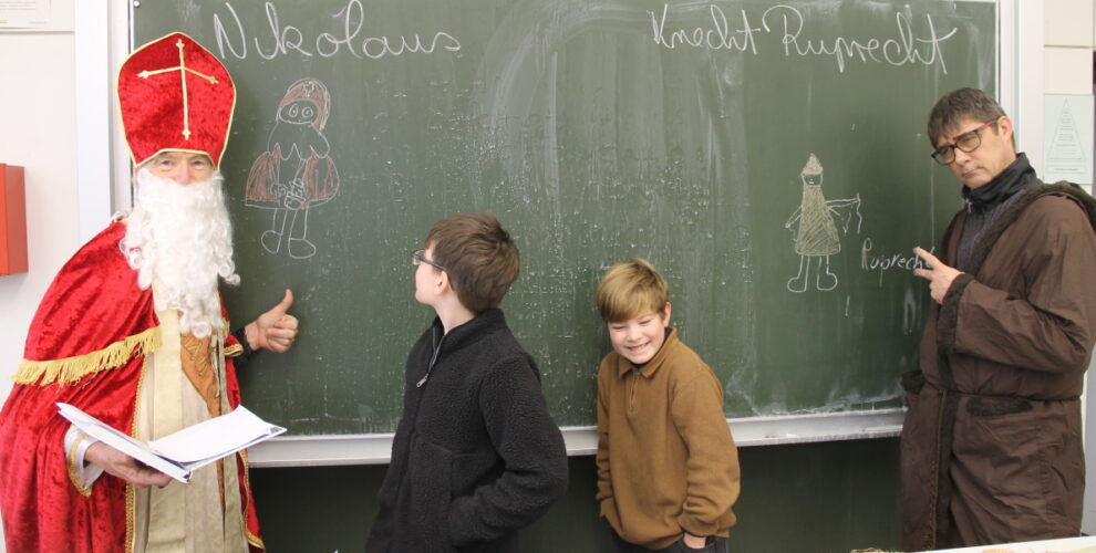 Nikolaus und Knecht Rupprecht vor ihren Abbildern und den beiden verantwortlichen Künstlern